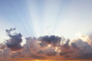 man raising his arms on sea under black clouds