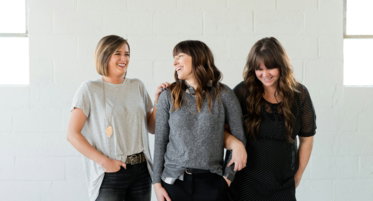 woman in gray crew neck t-shirt standing beside woman in black and gray long sleeve
